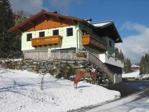 een huis in de sneeuw met een stenen muur bij Haus Schütter in Schladming