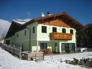 シュラートミンクにあるHaus Schütterの雪の中に木の屋根を持つ大きな家