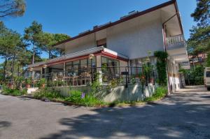 a building with a balcony with flowers on it at Hotel Caracas in Lignano Sabbiadoro