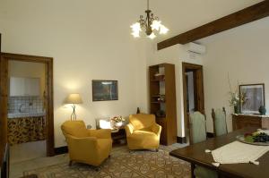 a living room with two yellow chairs and a table at Antica Dimora Benanti in Milo