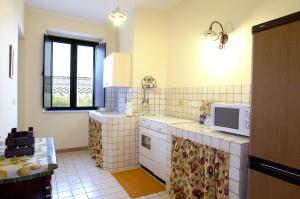 a kitchen with a sink and a microwave at Antica Dimora Benanti in Milo +38 photos