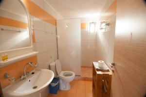 a bathroom with a white sink and a toilet at Elounda Sunrise Apartments in Elounda