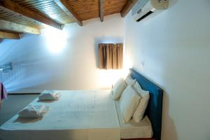 a bedroom with a bed with white sheets and pillows at Elounda Sunrise Apartments in Elounda