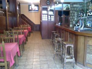 un restaurante con mesas y taburetes en un bar en Hostal Pumar, en Santiago de Compostela