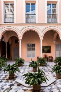 un bâtiment avec une cour ornée de plantes en pot dans l'établissement Palacio Mármoles, à Séville