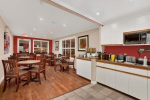 a kitchen and dining room with tables and chairs at Ramada by Wyndham Sherwood Park in Sherwood Park