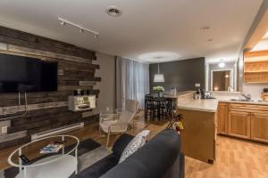 uma sala de estar e cozinha com um sofá e uma mesa em Lester Lofts by Bower Boutique Hotels em Moncton