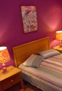 a bedroom with a bed and two tables with lamps at Quinta de Santana - Queimadas in Furnas