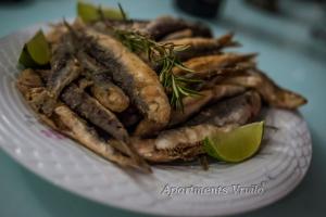 um prato de comida com um monte de batatas fritas em Apartments Vrvilo em Rogoznica