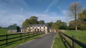 a farm house on a road with a fence at Moynure House Boutique B&B in Athlone