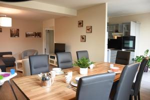 a dining room and living room with a wooden table and chairs at Grand Appartement Vue Cathédrale in Metz