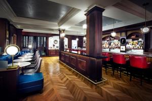 a restaurant with a bar with red chairs at The Adelphi Hotel in Saratoga Springs
