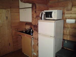 a kitchen with a microwave on top of a refrigerator at Huntingbox in Purila