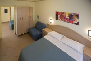 een slaapkamer met een bed en een blauwe stoel bij Residence Anchisemare in Alba Adriatica +61 foto's