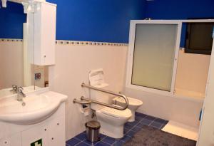 a white toilet sitting next to a sink in a bathroom at Quinta de Santana - Queimadas in Furnas