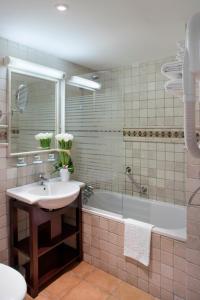 a bathroom with a sink and a bath tub at Hôtel Relais Acropolis Nice in Nice