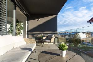 a patio with a couch and chairs on a balcony at Apartments Villa Popp in Ljubljana