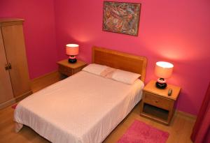 a bedroom with a bed and two night stands with lamps at Quinta de Santana - Queimadas in Furnas
