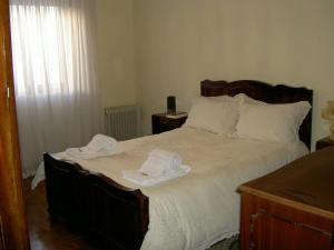 um quarto com uma cama grande e toalhas em Âncora Apartment em Vila Praia de Âncora
