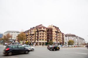 a street with cars driving down a street with buildings at Stan na dan Angel in Novi Sad