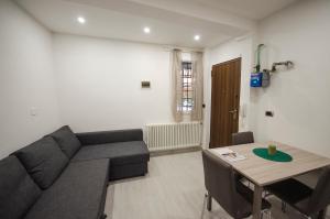un soggiorno con divano e tavolo di Bibiena Lodge, appartamento moderno in centro a Bologna