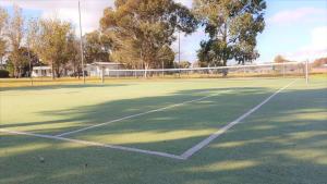 a person playing tennis on a tennis court at Discovery Parks - Moama West in Moama