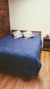 a blue bed with two pillows on top of it at Cabañas Avenida España in Punta Arenas