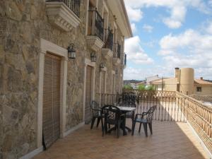 patio con mesa y sillas en el balcón en Complejo Peñafiel, en Zarza la Mayor