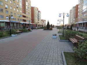 une rue avec bancs et bâtiments dans une ville dans l'établissement Apart-Hotel on Solnechniy 10, à Joukovski