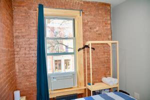 a bedroom with a brick wall and a window at Morris Guest House in Bronx