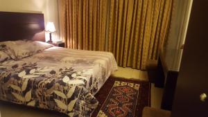 a hotel room with a bed and a rug at West House Residence in Beirut