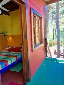 a colorful room with a bed and a window at B&B Mi Casa Es Tu Casa in Mar Azul
