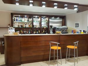 a bar with two stools and bottles of alcohol at Hotel Santa Caterina in Fisciano