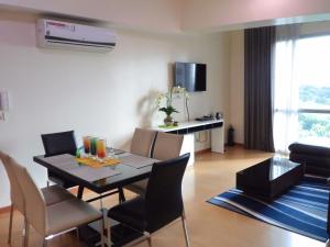 a dining room and living room with a table and chairs at Avant Apartments at The Fort in Manila