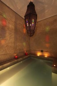 a bath tub with a chandelier in a room at Riad O2 in Marrakech