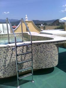 a swimming pool with a metal ladder next to a swimming pool at Spa Hotel Holiday in Velingrad