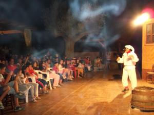 a man in a santa hat on a stage with a crowd at Family Resort Cala di Luna in Marina di Camerota