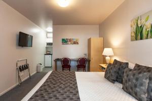 a bedroom with a bed and a table with chairs at Ararat Motor Inn in Ararat
