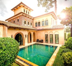 an exterior view of a house with a swimming pool at Chivani Pattaya in Na Jomtien