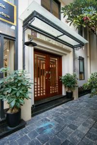 a front door of a building with two potted plants at Au Coeur d'Hanoi Apartment in Hanoi