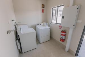 a small laundry room with a washer and dryer at Studios On Beaumont in Newcastle