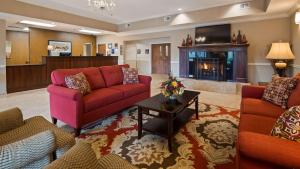 a living room with two couches and a fireplace at Best Western Plus Louisa in Louisa