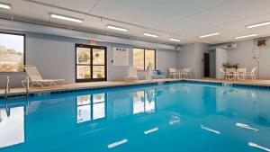 a swimming pool with blue water in a building at Best Western Plus Louisa in Louisa