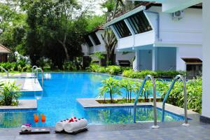 a swimming pool with two shoes in a resort at Nihara Resort and Spa Cochin in Cochin