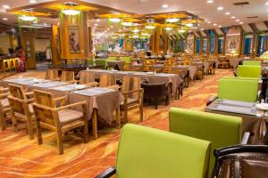 a dining room with tables and chairs in a restaurant at Hotel Silverland in Dongguan