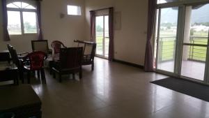 a dining room with a table and chairs and windows at A-Ma Homestay in Fengli