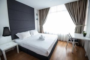 a bedroom with a bed and a desk and a window at Vortex KLCC by Luxury Suites Asia in Kuala Lumpur