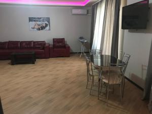 a living room with a glass table and a couch at Penthouse studio in Sukhum