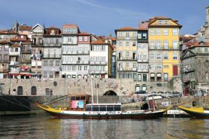 un barco está atracado en el agua junto a los edificios en Apartamentos sobre o Douro, en Oporto