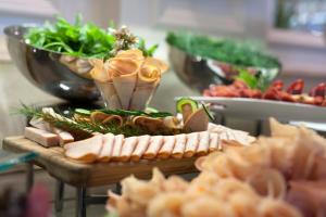 a table topped with meats and vegetables on a table at Elite World Istanbul Florya in Istanbul